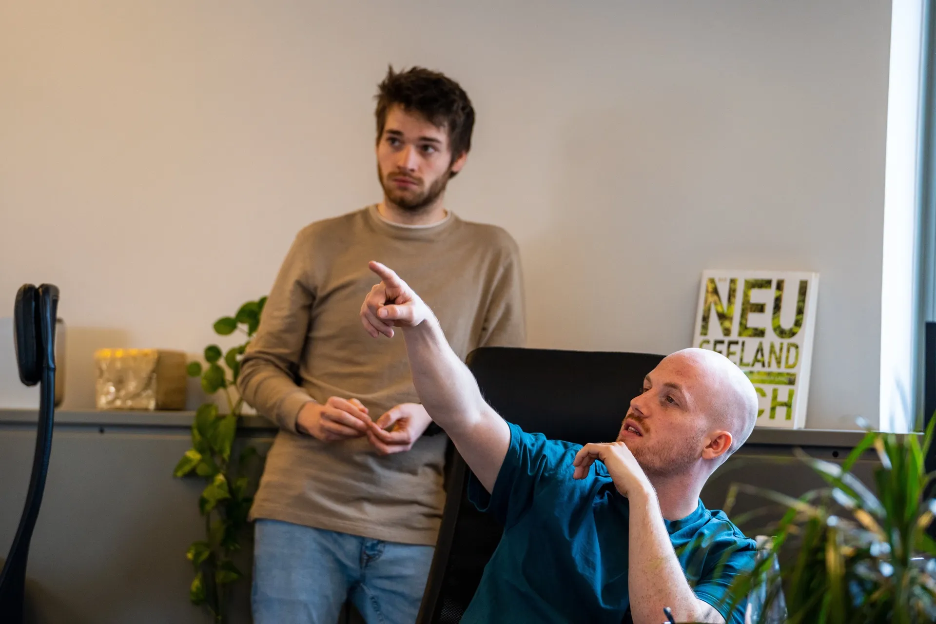 Two Dotbite engineers discussing a process, one pointing across the room.